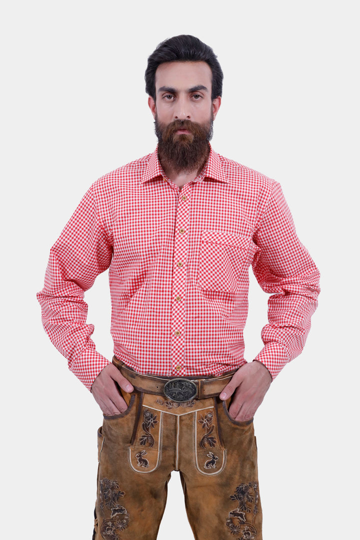 Close-up view of a man wearing Chiemsee Lederhosen and a pink checkered shirt, showing the detailed embroidery on the leather shorts.