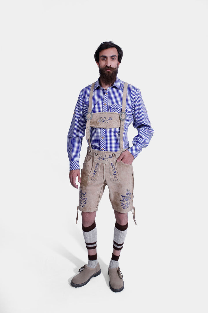 Full-body view of a man wearing beige-colored Cincinnati Lederhosen paired with a blue checkered shirt and beige-colored shoes, demonstrating traditional Bavarian attire.