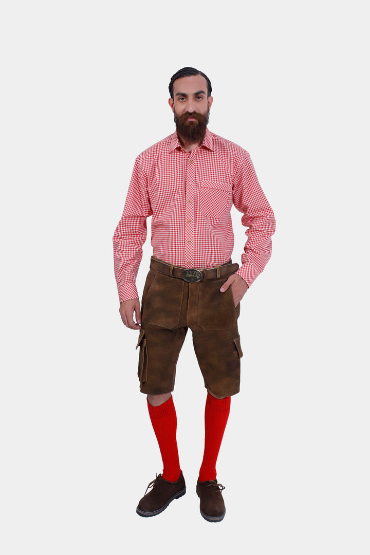 Full body shot of a man wearing DJ Ötzi Cargo Lederhosen and a red checkered shirt, paired with red knee-high socks and brown shoes. Cargo Lederhose kurz