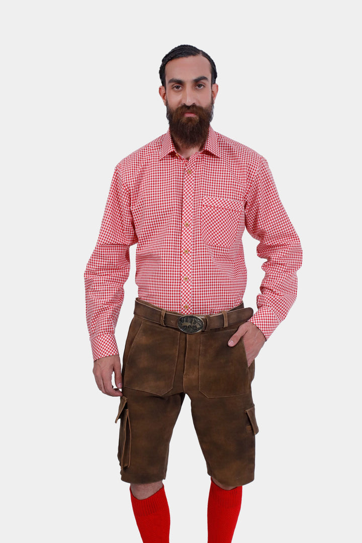 A bearded man wearing a red checkered shirt paired with DJ Ötzi Cargo Lederhosen, posing with his hands in his pockets.