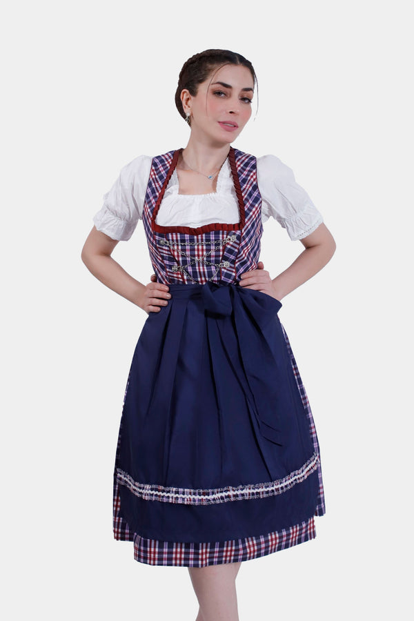 Woman in Dirndl Hilker, hands on hips, showcasing the sapphire bodice with plaid accents and a flowing navy skirt. blaues dirndl , dirndl blau festlich