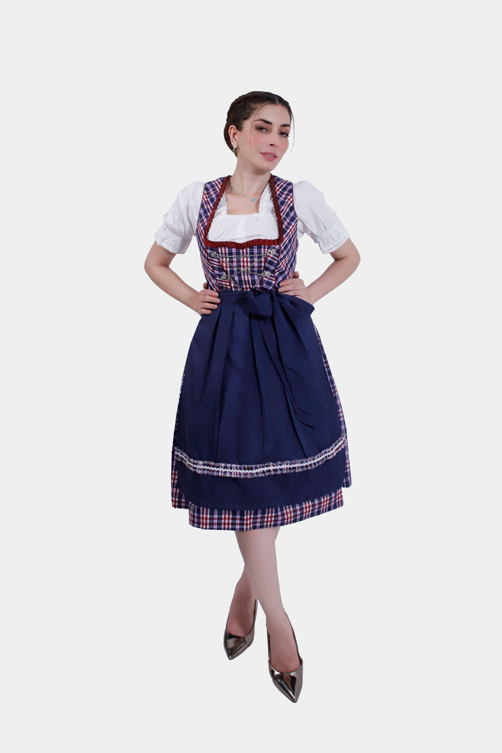 Full-length view of a woman wearing Dirndl Hilker, featuring a tailored sapphire bodice and navy skirt with a matching apron.