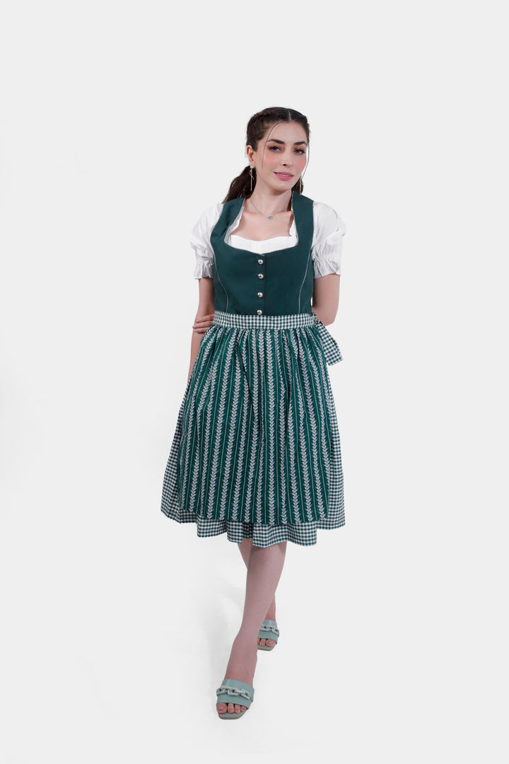 Full-length view of a woman standing in Dirndl Sukowa, styled with a green bodice, patterned skirt, and a gingham apron, complemented by green sandals.