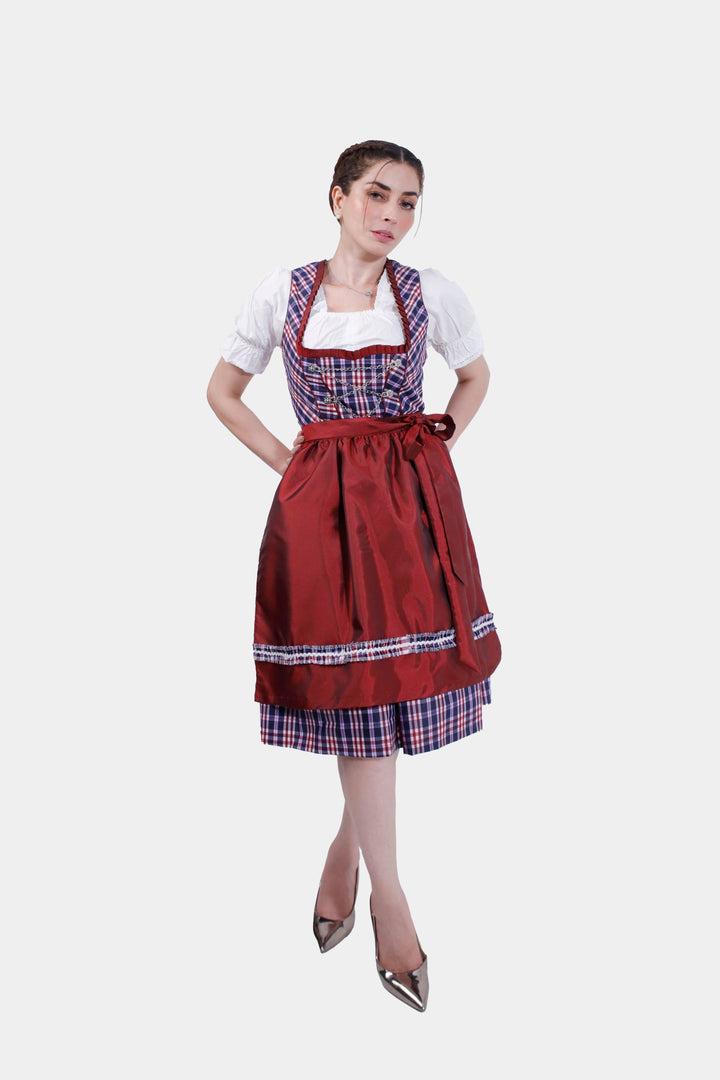 Full-length view of a woman wearing Dirndl Zsa Inci, highlighting the detailed crimson skirt and plaid apron.