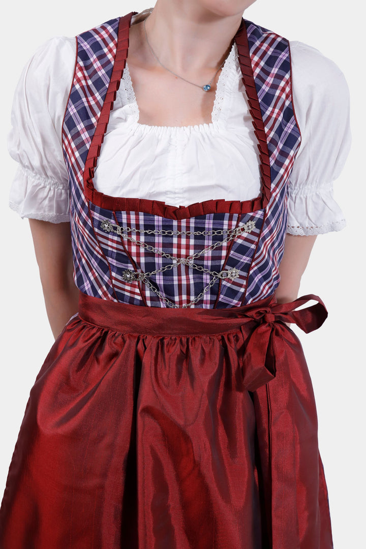 Close-up of the Dirndl Zsa Inci's bodice, featuring intricate silver embellishments and a plaid pattern.