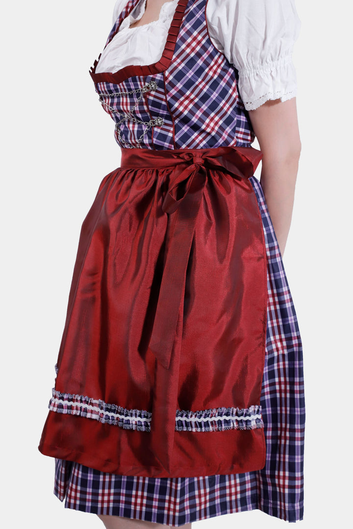 Left Side view of a woman in Dirndl Zsa Inci, emphasizing the plush crimson skirt and decorative apron.