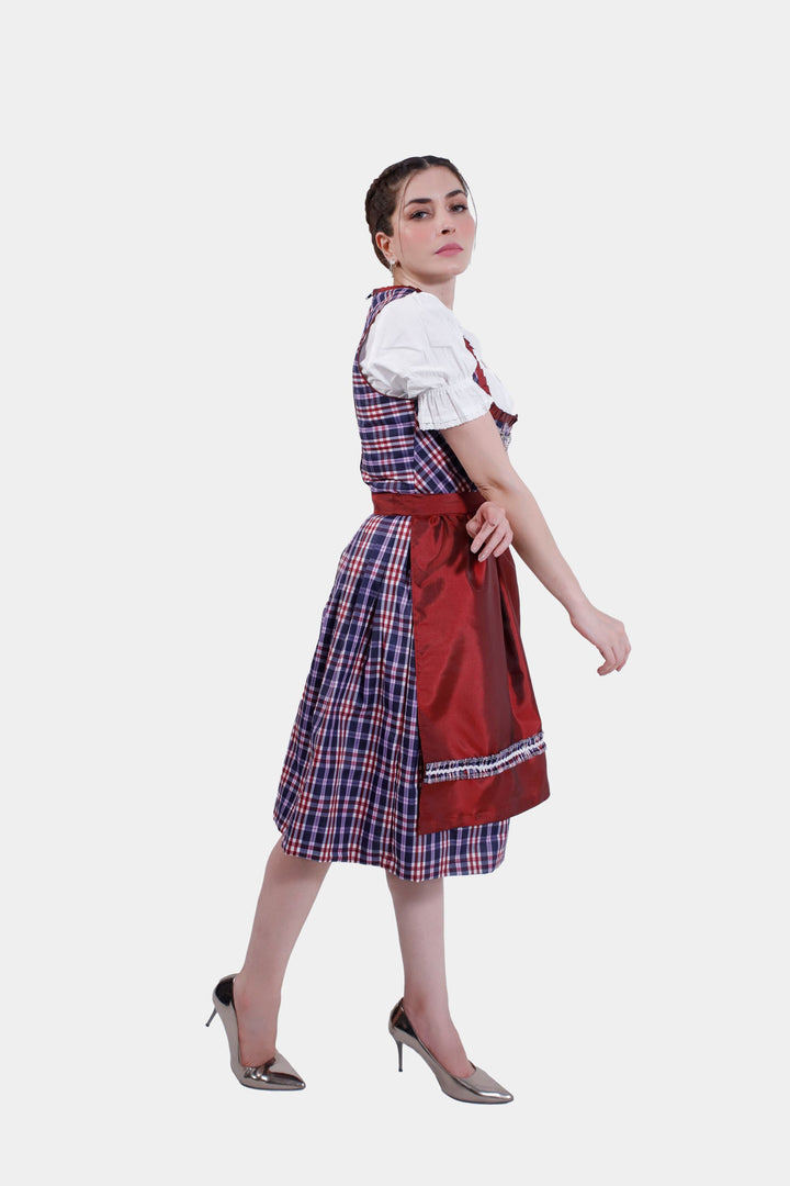 Rear view of Dirndl Zsa Inci, displaying the intricate tie of the crimson apron against a plaid skirt.