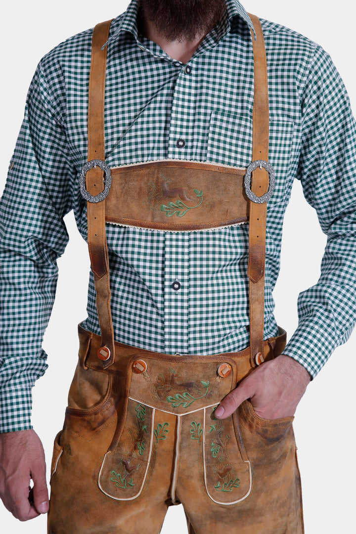 Detailed view of the Durant Lederhosen Outfit, focusing on the chest and waist area. The Lederhosen has leather suspenders and intricate green embroidery on the front flap.