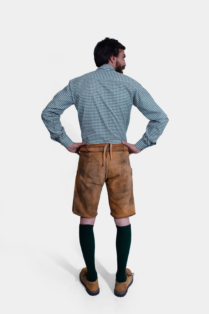 Rear view of a man wearing the Durant Lederhosen Outfit, showing the back of the green checkered shirt and the brown leather Lederhosen with a back tie detail.