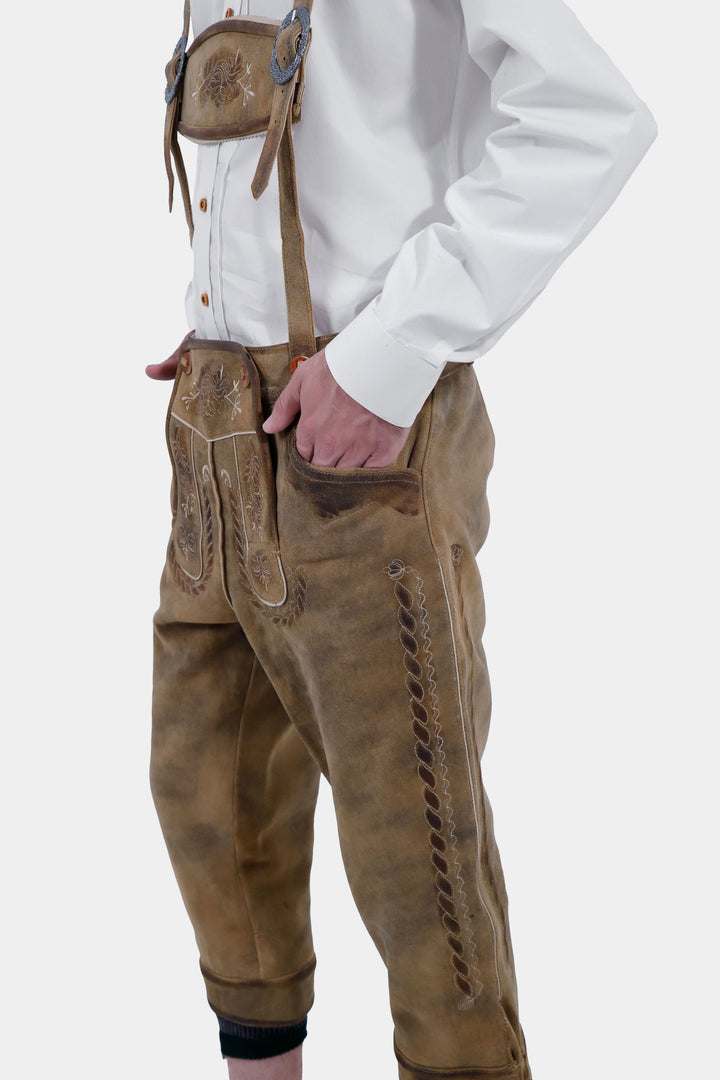 Side close-up view of a man wearing the Edinburgh Castle Bundhosen, showcasing the detailed embroidery  paired with a white shirt