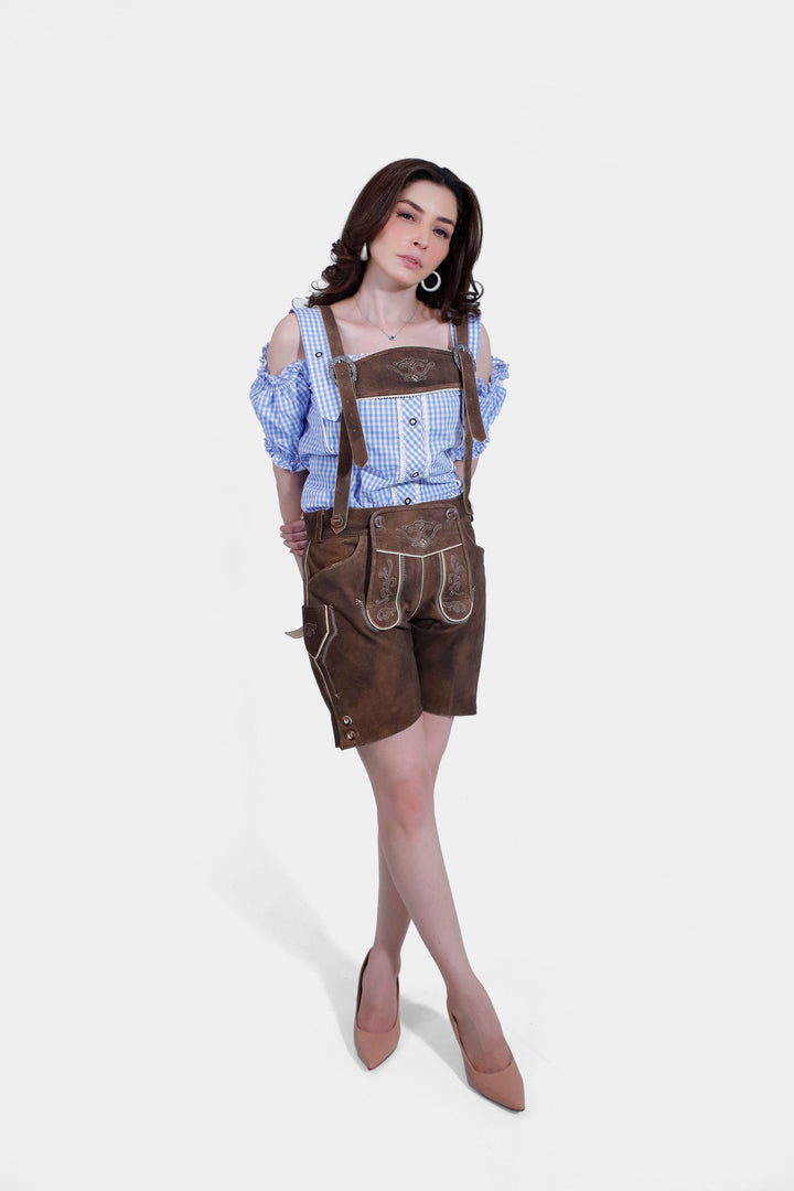 Elegant pose in Elsa Lederhosen, focusing on the contrast between the leather shorts and the blue checkered blouse.