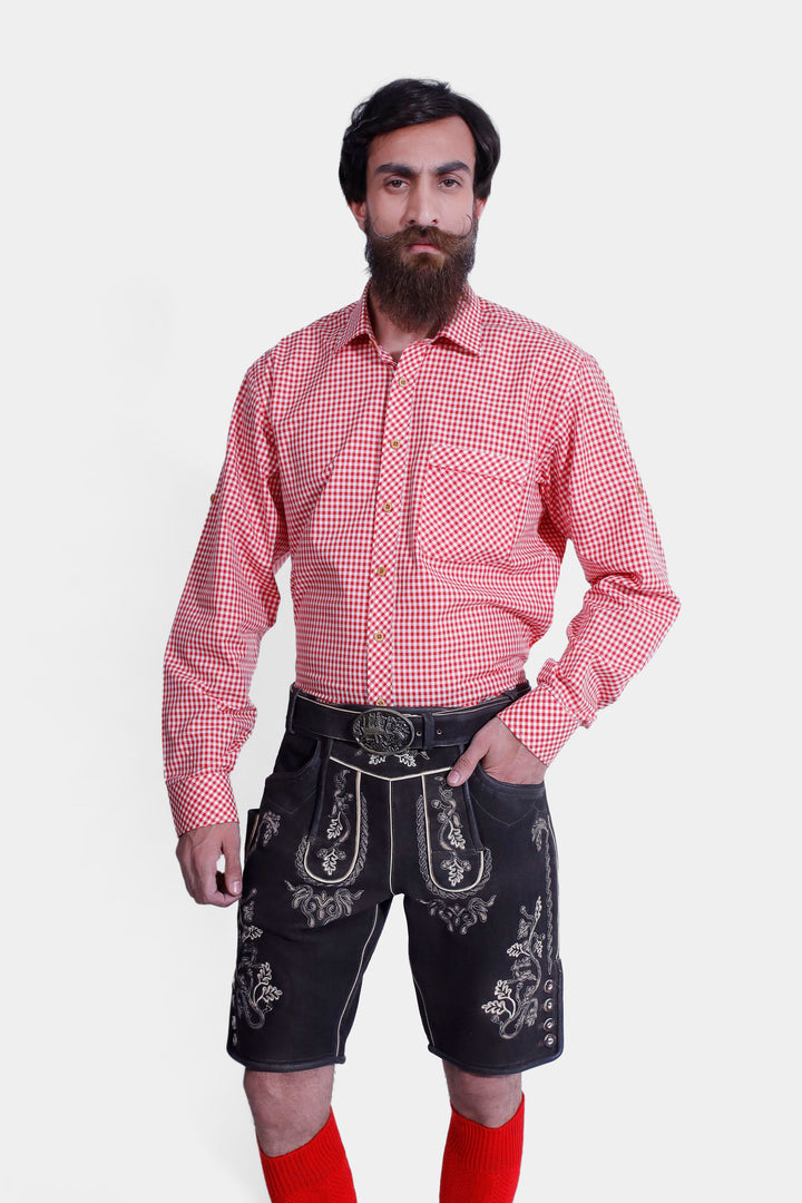 Close-up view of a man in an Everglades Lederhosen Outfit, showcasing the red and white checkered shirt and black leather lederhosen with white embroidery and a decorative belt buckle.