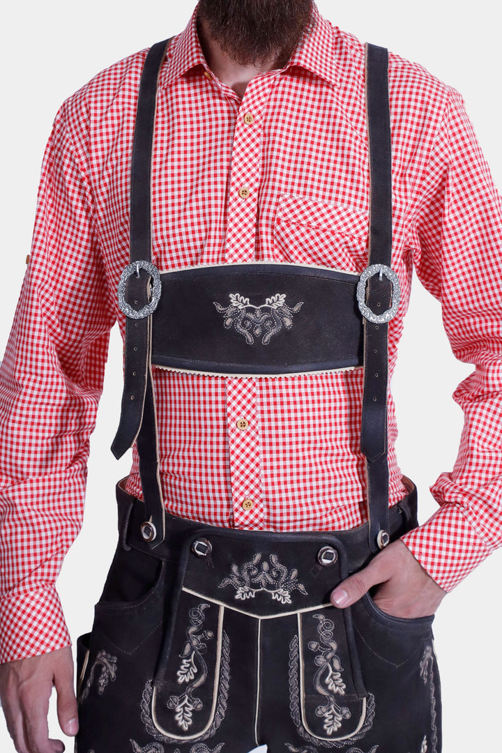 Front view of a man in an Everglades Lederhosen Outfit, showing the red and white checkered shirt, black leather lederhosen with white embroidery, and decorative suspenders.