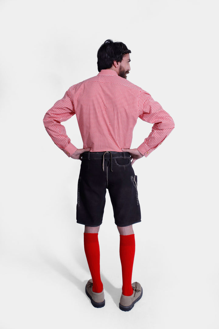 Rear view of the Everglades Lederhosen Outfit, displaying the black leather lederhosen and red and white checkered shirt from behind, with hands on hips