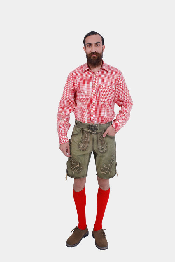 A man wearing the Heidelberg Lederhosen in Meadow Green, paired with a red checkered shirt, showcasing the front view with detailed embroidery and red socks. lederhose in grüne, lederhose grün 