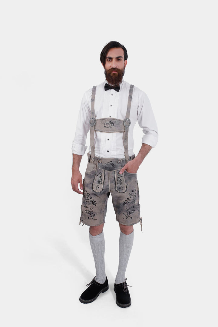 Man standing in Hofburg Lederhosen with white dress shirt, black shoes, and gray knee-high socks, full body shot.