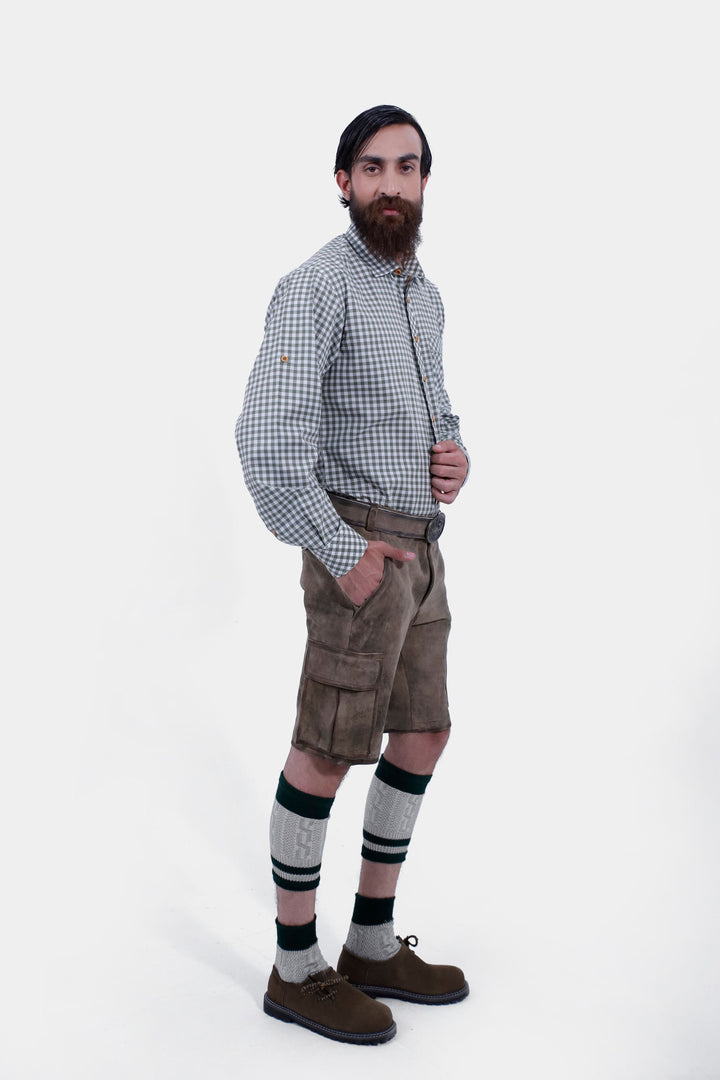 Side profile of a man in Klimt Cargo Lederhosen, emphasizing the gray-brown leather shorts' design and fit, paired with a gray checkered shirt.