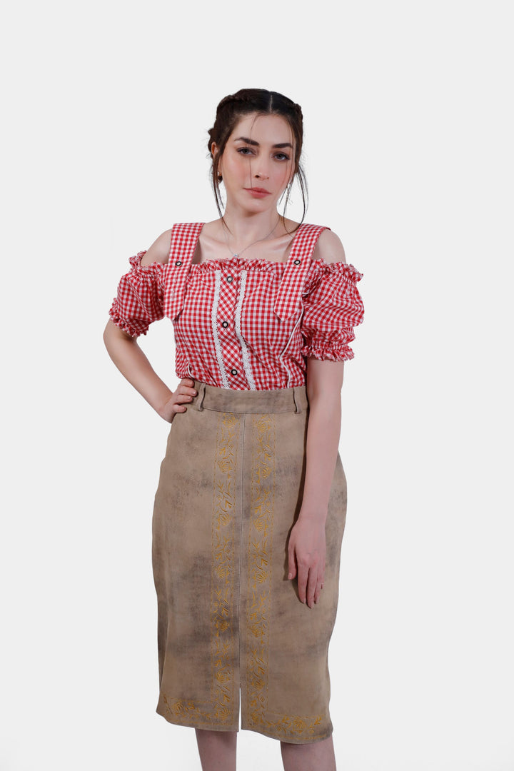 Full front view of the model wearing the Kollwitz Lederhosen Skirt in sandy tan buck skin leather, showing the intricate embroidery, paired with a red and white checkered blouse.