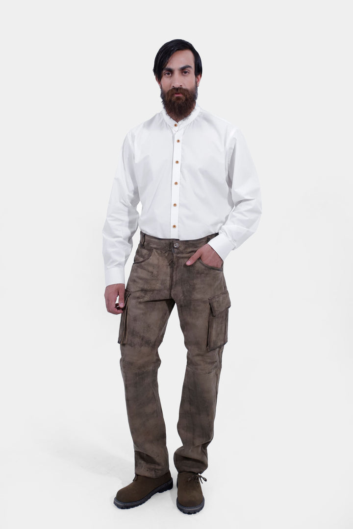 Full-body view of a person standing confidently, dressed in Königssee Cargo Lederhosen Long Pant with decorative side stitching and a white button-up shirt. herren trachten lederhose lang​