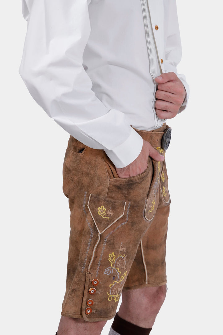 Another side view of the man wearing Leavenworth lederhosen, showing the detailed embroidery and button details on the side of the shorts.