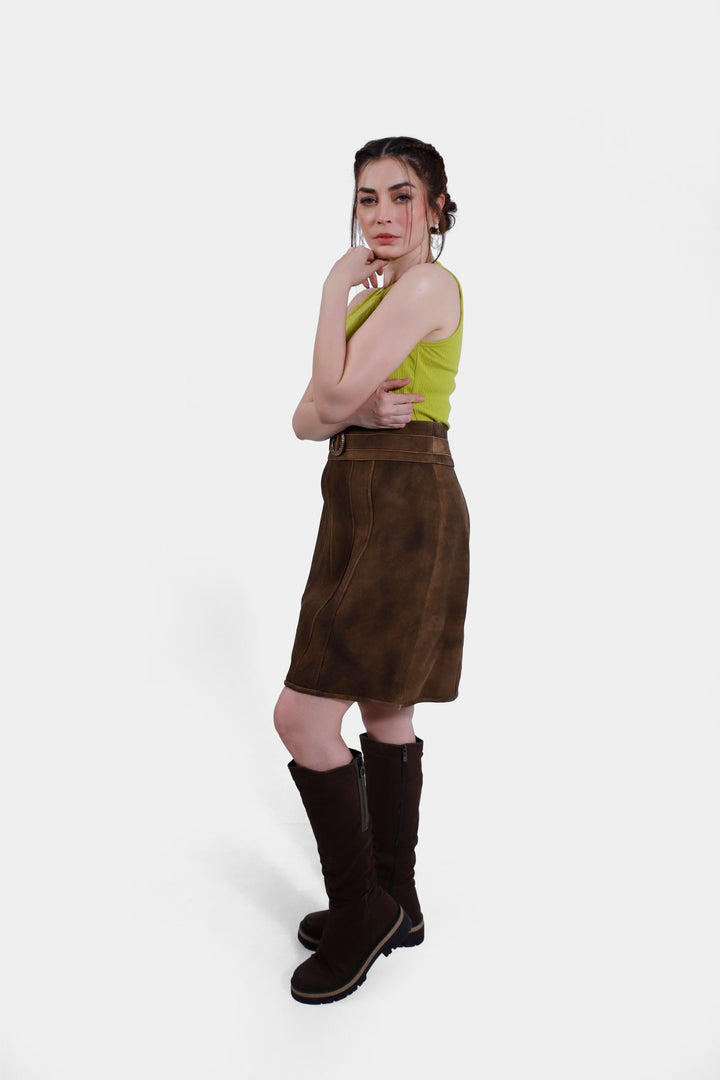 Model in the Leni Lederhosen Skirt in Rustic Oak, displaying the knee-length cut and paired with knee-high brown boots.