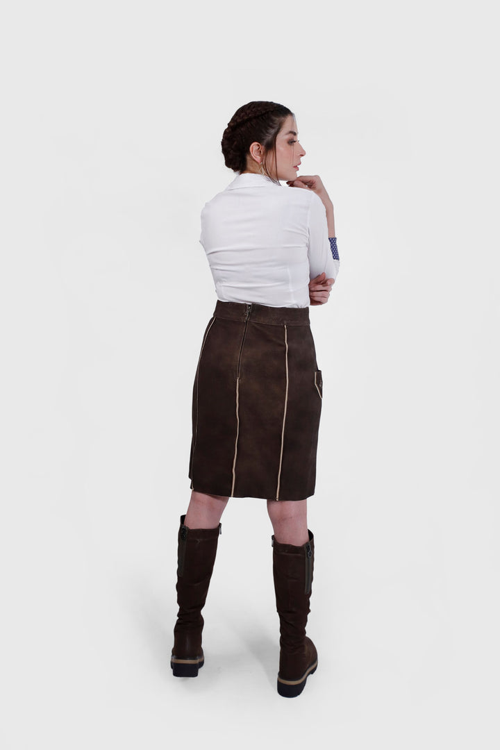 Back view of a woman wearing the Louise Lederhosen Skirt in dark brown leather, displaying the skirt's rear design and the zipper closure.