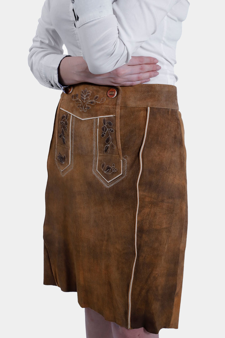 Close-up view of the Marianna Lederhosen Skirt, highlighting the detailed embroidery on the front pockets and waist area.