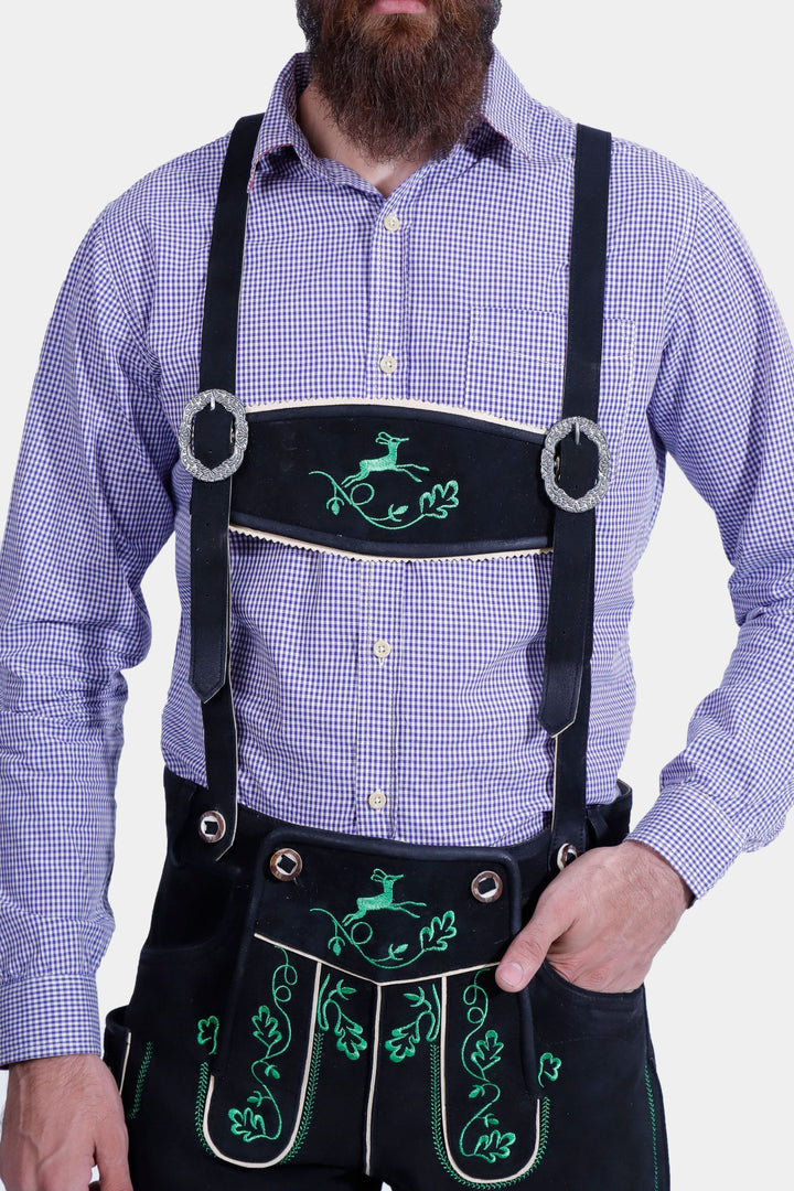 Front view of a man in the Melk Abbey Lederhosen Outfit, showing the purple checkered shirt, black leather lederhosen with green embroidery, and decorative suspenders.