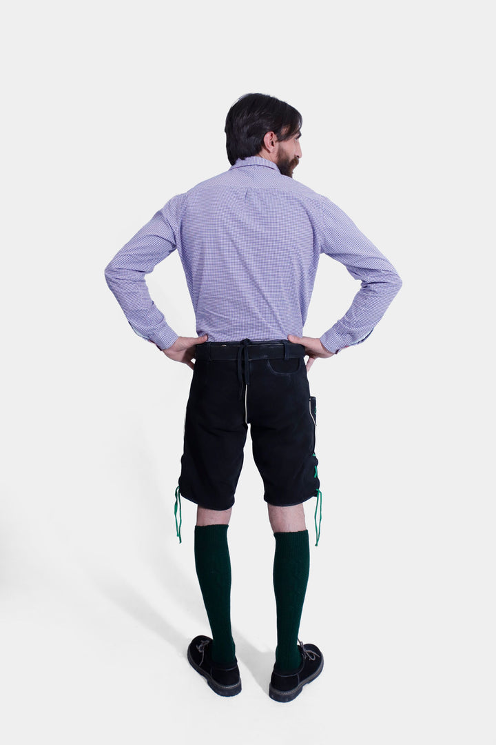 Rear view of the Melk Abbey Lederhosen Outfit, displaying the black leather lederhosen and purple checkered shirt from behind, with hands on hips.