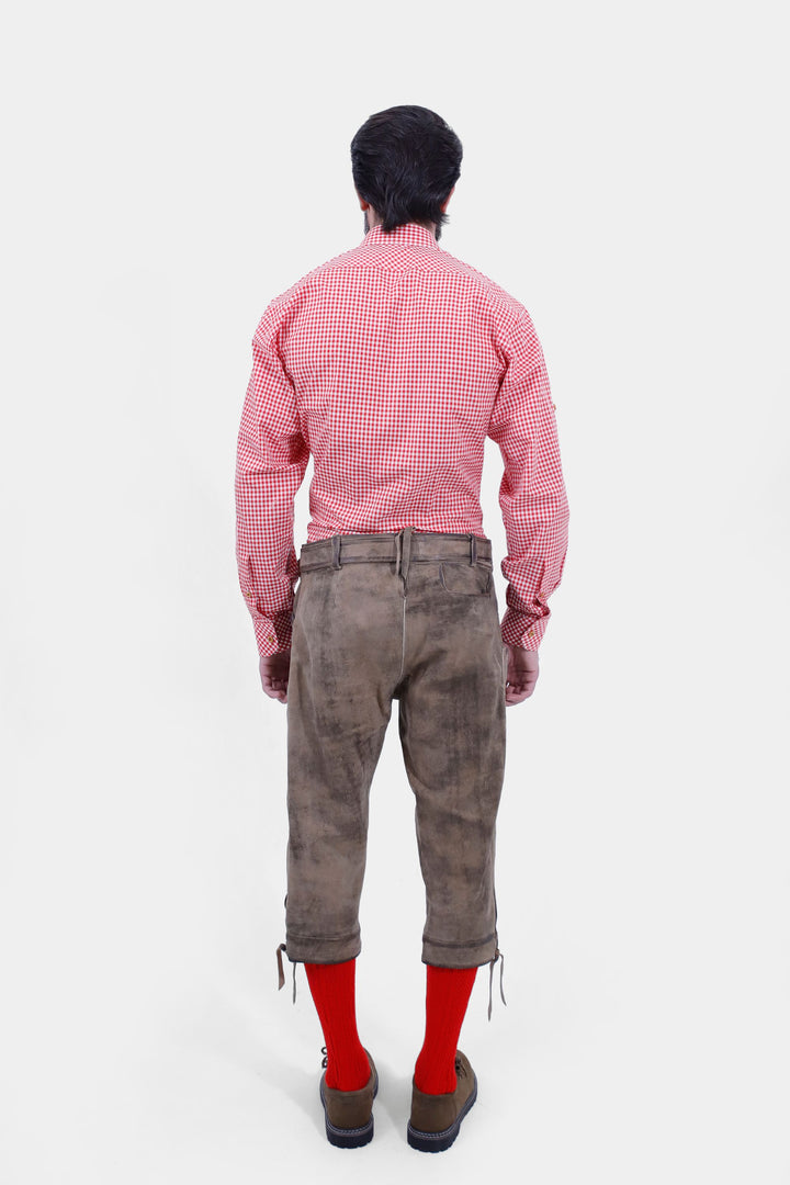  Rear view of a man wearing Milwaukee Old World  Bundhosen. . He is dressed in a red checkered shirt, red socks, and brown shoes, showcasing the back design.