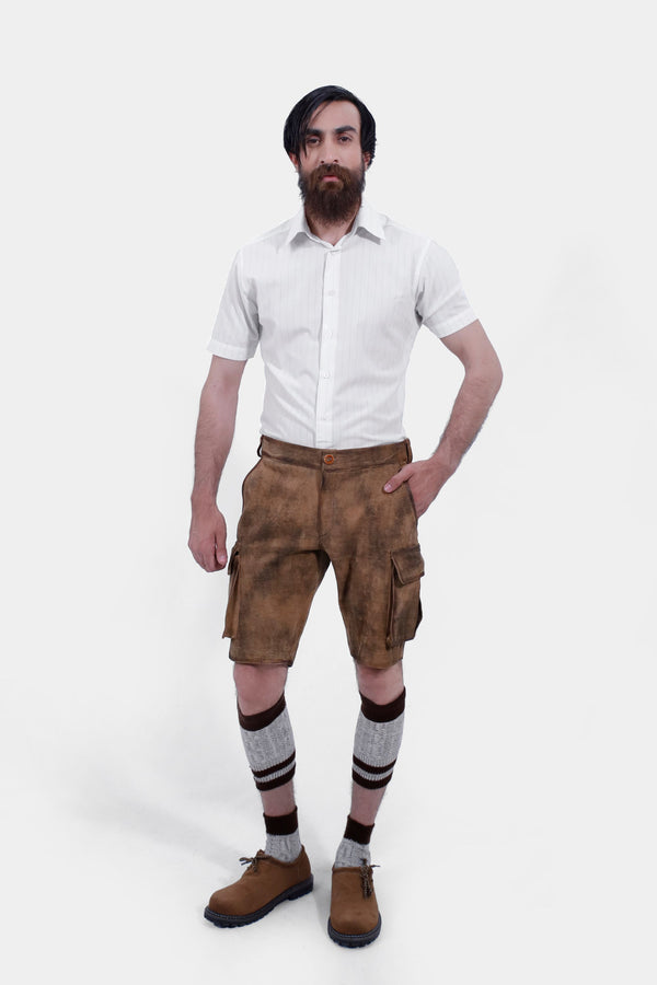 Man wearing Snowbird Cargo Lederhosen with a white dress shirt, standing with hands in pockets including brown and knee-high socks and brown shoes. herren lederhosen kurz, kurze herren lederhose​