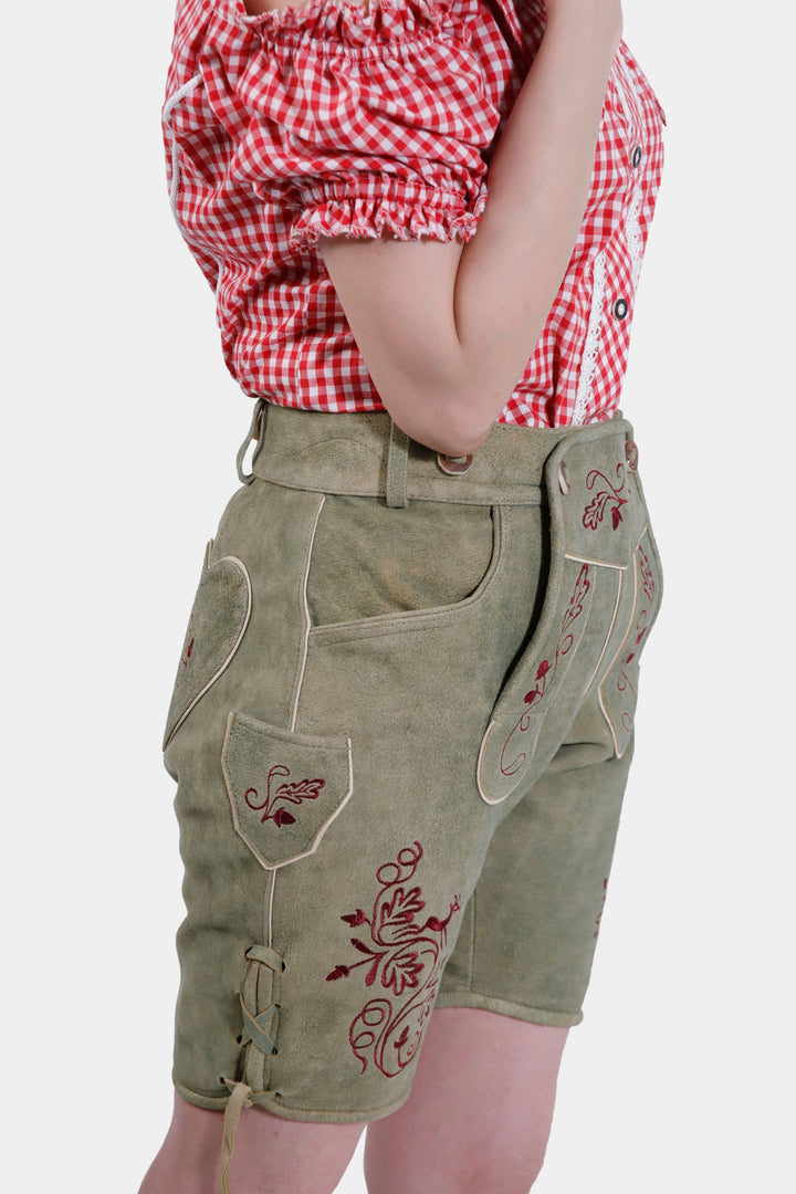 Woman posing in Oliviaa Charm Lederhosen, emphasizing the and the elegant embroidery detail.