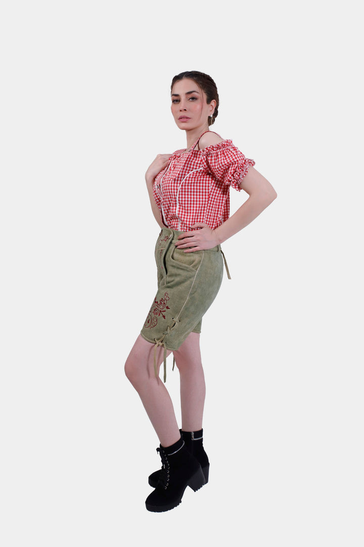 Woman posing in Olivia Charm lederhosen, accentuating the side embroidery and overall traditional Bavarian style.