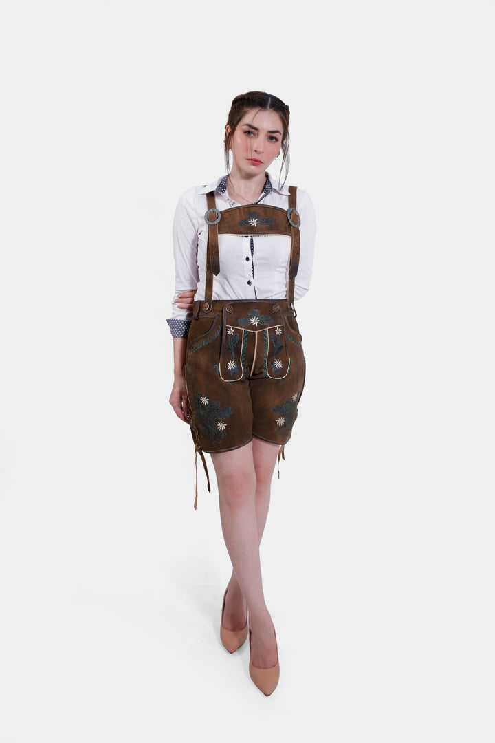 Full front view of a woman in Romy Schneider lederhosen, showing the entire outfit with the brown horn buttons on the bib and adjustable waistband.