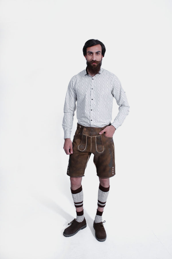 Brown leather lederhosen with intricate embroidery and button details, worn by a man against a white background. kurze lederhose herren, trachten lederhose herren​