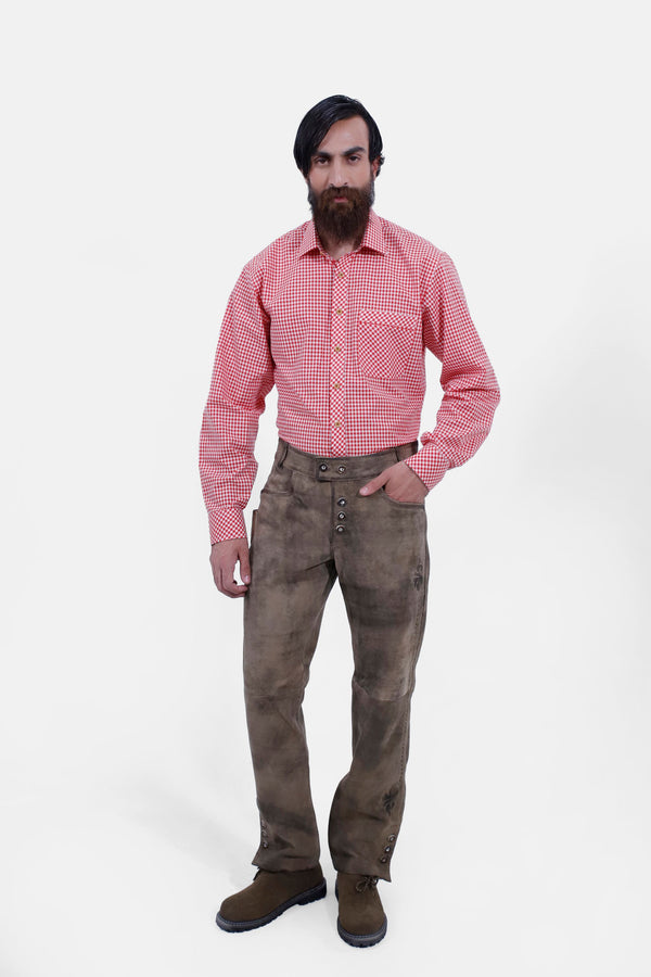 Full-body view of a person standing confidently, dressed in Wachau Valley Lederhosen Long Pant with decorative side stitching and a red and white checkered shirt. lederhosen herren lang​