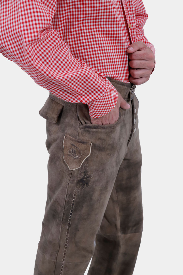 Side view of a person showcasing the details of Wachau Valley Lederhosen Long Pant with embroidered pockets, wearing a red and white checkered shirt.