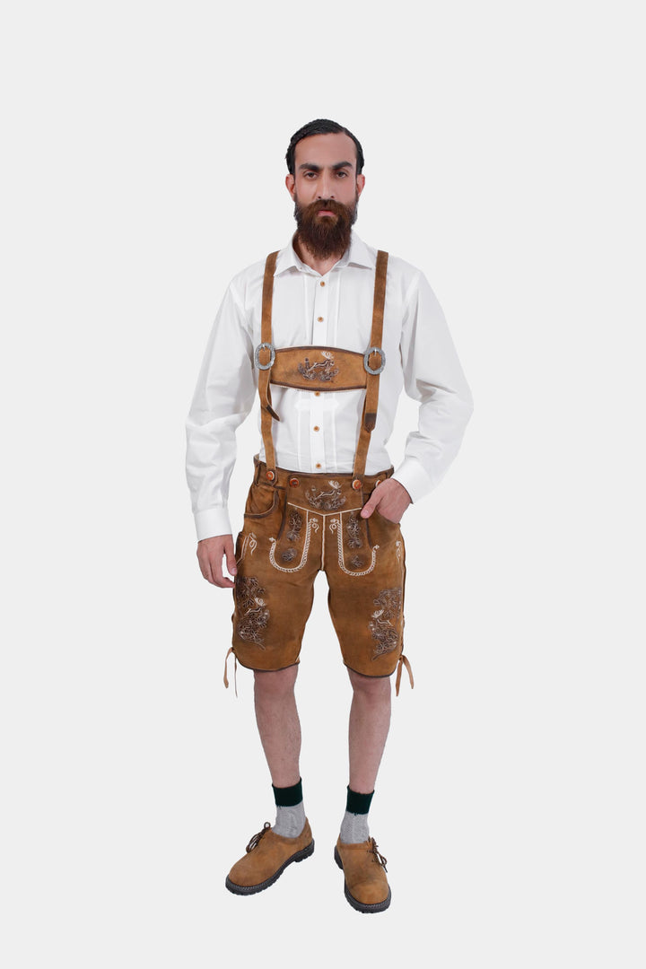 Man in Freud Lederhosen and white shirt with suspenders, highlighting detailed embroidery and rustic style buckles.