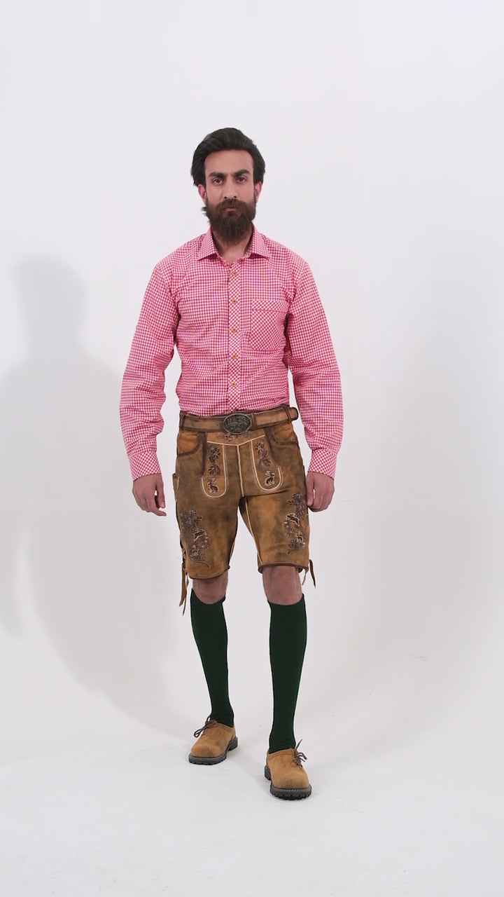 Video showcasing the Chiemsee Lederhosen from every angle, highlighting the detailed embroidery, fit, and traditional design of the leather shorts. The model rotates slowly, allowing a full 360-degree view of the product, including front, side, and back perspectives, as well as close-up shots of the suspenders and decorative elements.