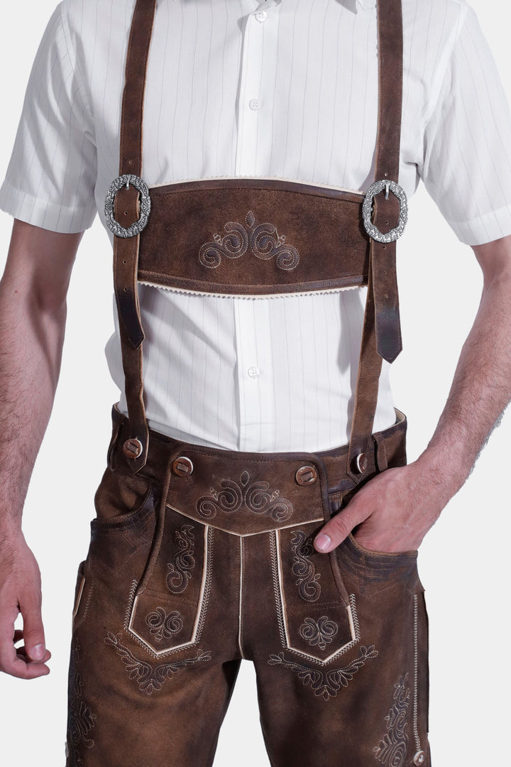 Man in Richard Strauss Lederhosen with white dress shirt and black bow tie, close-up on chest and lederhosen front.